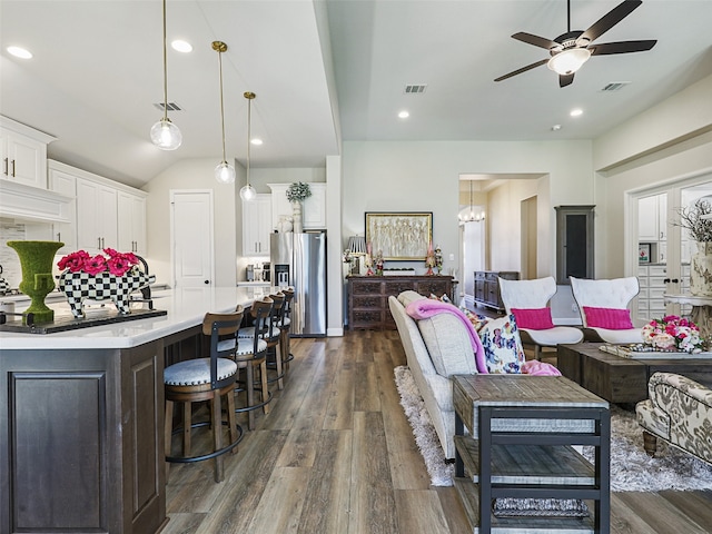 living room with dark wood-style floors, visible vents, and a ceiling fan