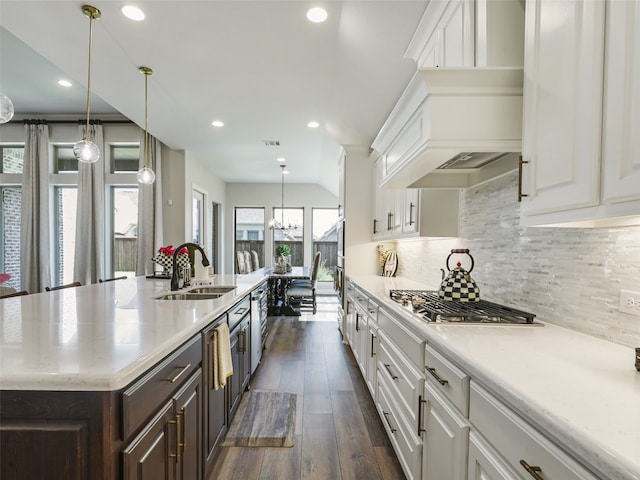 kitchen with white cabinets, a sink, backsplash, and dark brown cabinets