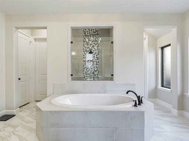 full bathroom featuring marble finish floor, baseboards, a garden tub, and tiled shower