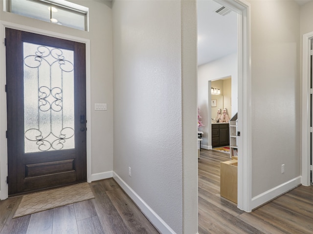 entryway featuring visible vents, baseboards, and wood finished floors