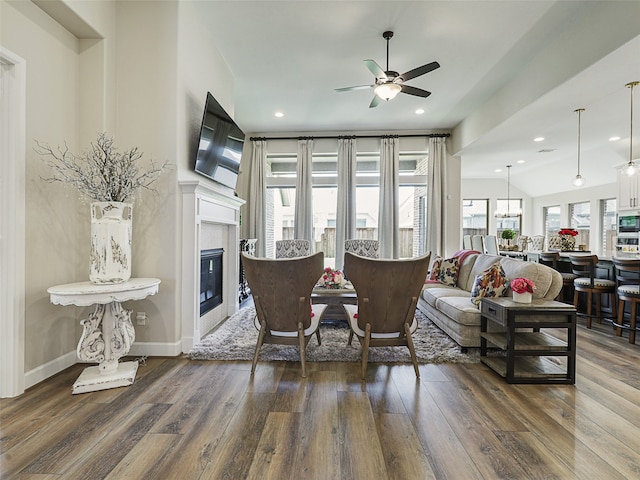 living area with ceiling fan, wood finished floors, and a glass covered fireplace