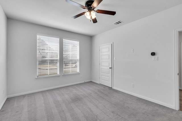 carpeted spare room with visible vents, ceiling fan, and baseboards