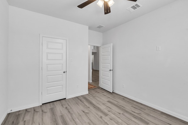 unfurnished bedroom featuring a ceiling fan, baseboards, visible vents, and wood finished floors