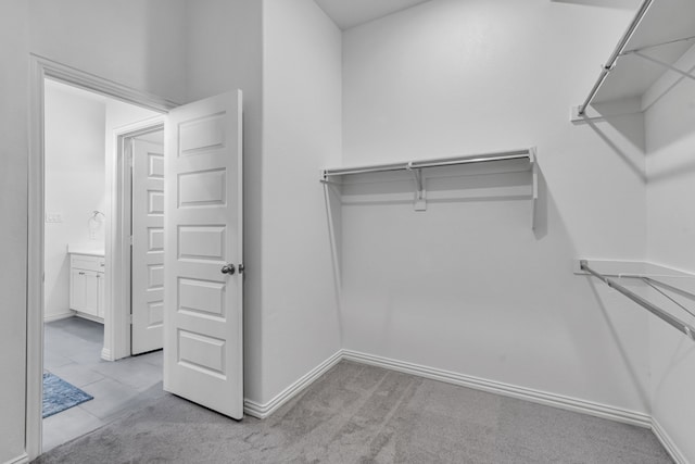 walk in closet featuring light carpet