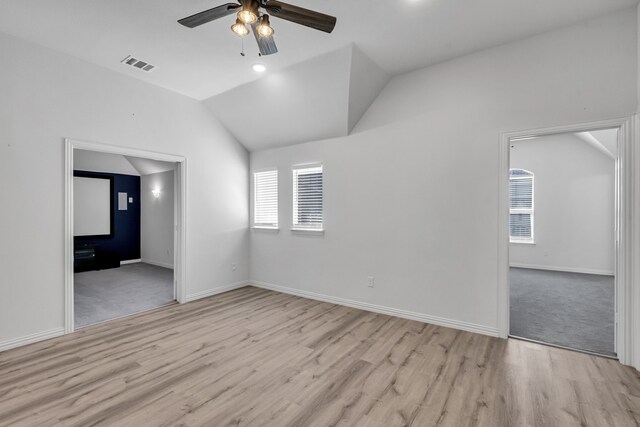 spare room with a ceiling fan, a healthy amount of sunlight, visible vents, and vaulted ceiling