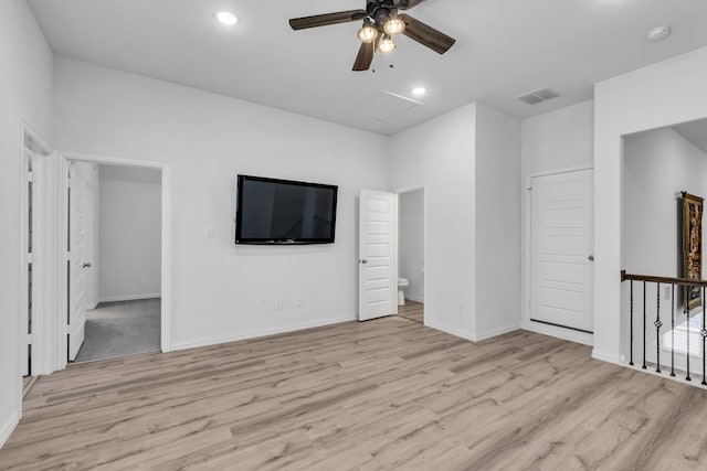 spare room with attic access, visible vents, light wood-style flooring, and baseboards