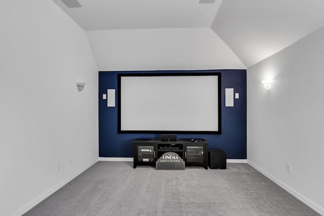 carpeted home theater room with baseboards and vaulted ceiling