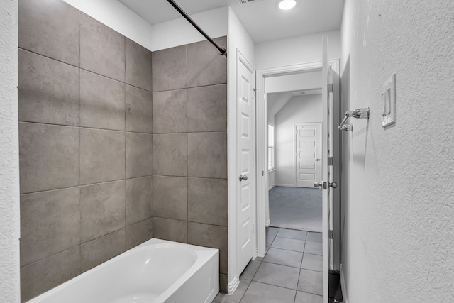 bathroom featuring tile patterned flooring and a textured wall