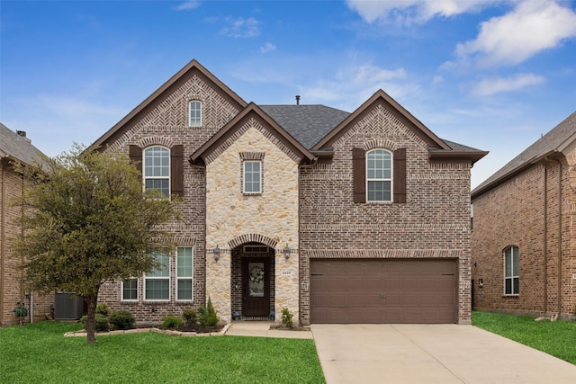 french country style house with a front yard, concrete driveway, brick siding, and central air condition unit