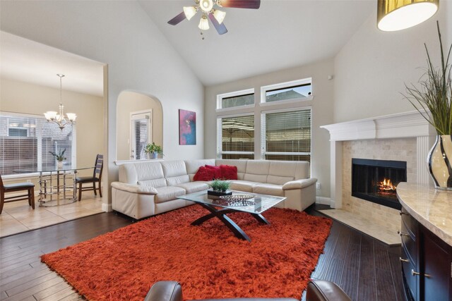 living room with arched walkways, dark wood-type flooring, and stairway