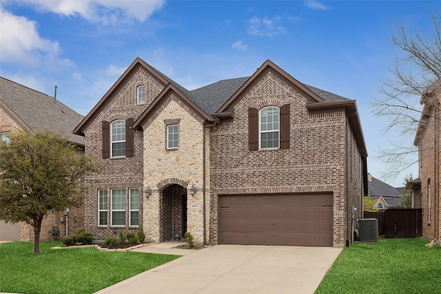 french provincial home with concrete driveway, brick siding, and a front yard