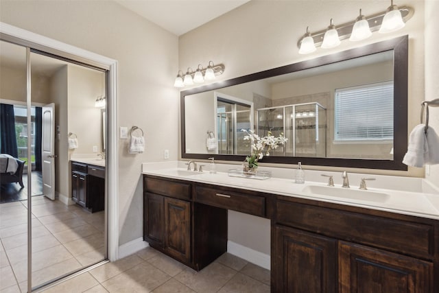 full bathroom with tile patterned floors, a sink, a shower stall, and double vanity