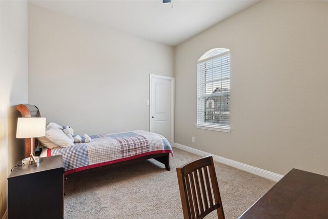 carpeted bedroom featuring a ceiling fan and vaulted ceiling