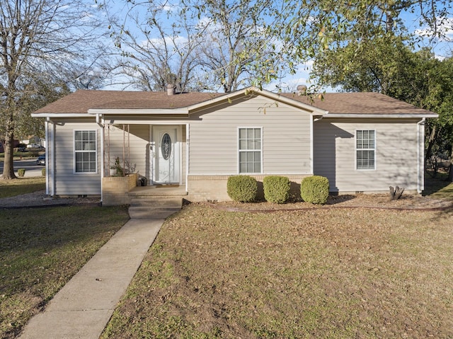 view of front of home with crawl space, roof with shingles, a chimney, and a front yard