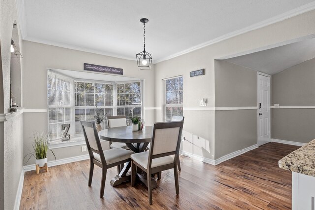 dining room with baseboards, wood finished floors, and ornamental molding