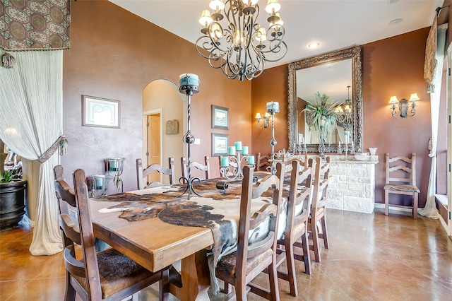 dining area with arched walkways, light tile patterned flooring, baseboards, and an inviting chandelier