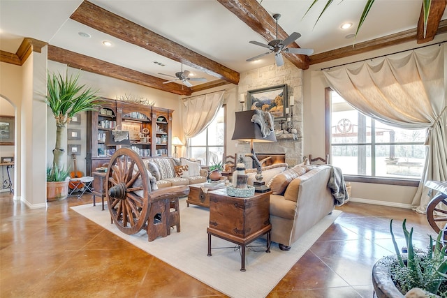 living area featuring beam ceiling, a fireplace, baseboards, and ceiling fan