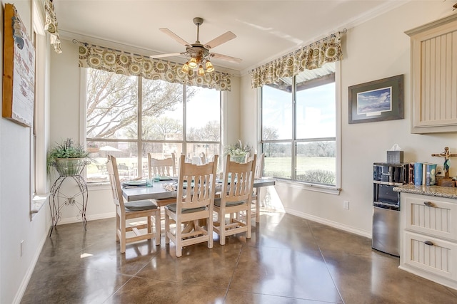 dining area with concrete floors, baseboards, a ceiling fan, and ornamental molding