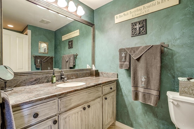 bathroom with toilet, visible vents, and vanity