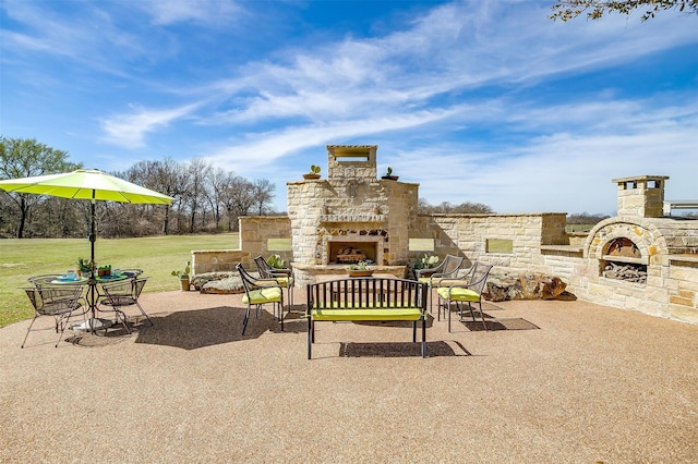 view of patio with an outdoor stone fireplace