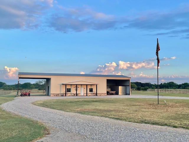 view of pole building with gravel driveway and a lawn