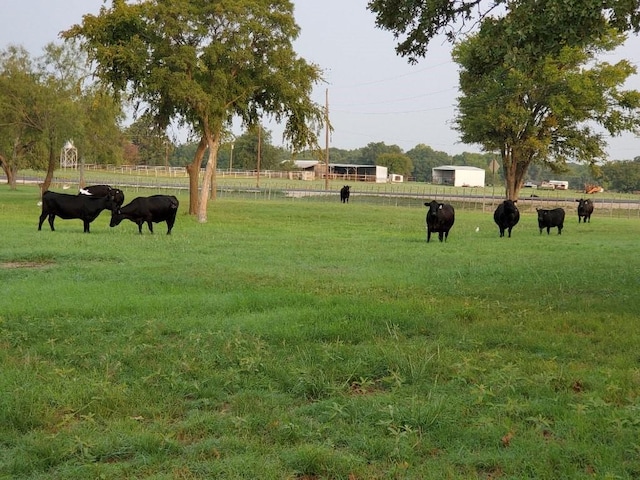 surrounding community with fence and a rural view