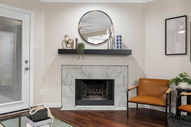 sitting room featuring a tiled fireplace and wood finished floors