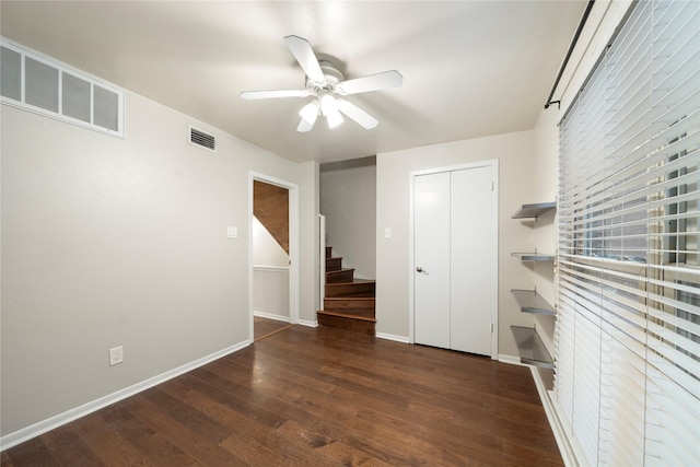 spare room with stairway, baseboards, visible vents, and wood finished floors