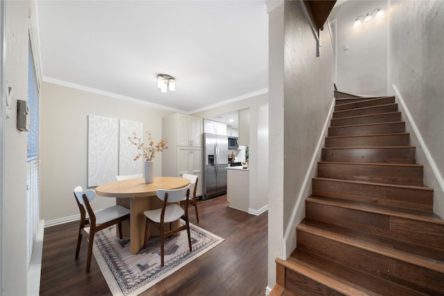 dining space featuring dark wood-style floors, ornamental molding, baseboards, and stairs