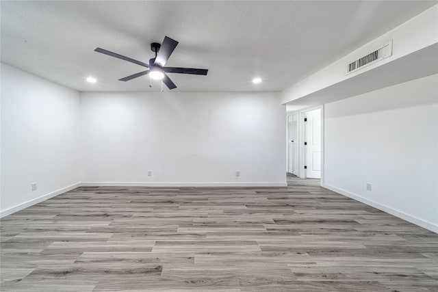 empty room with recessed lighting, wood finished floors, a ceiling fan, and baseboards