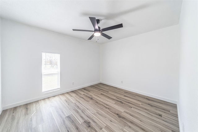 spare room with light wood-style flooring, ceiling fan, and baseboards