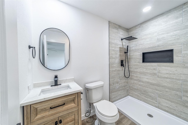6305 Pine St, Rowlett, TX 75089 - bathroom with tiled shower, toilet, vanity, and wood finished floors