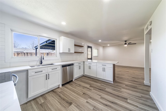 6305 Pine St, Rowlett, TX 75089 - kitchen with stainless steel dishwasher, a sink, a peninsula, white cabinets, and ceiling fan