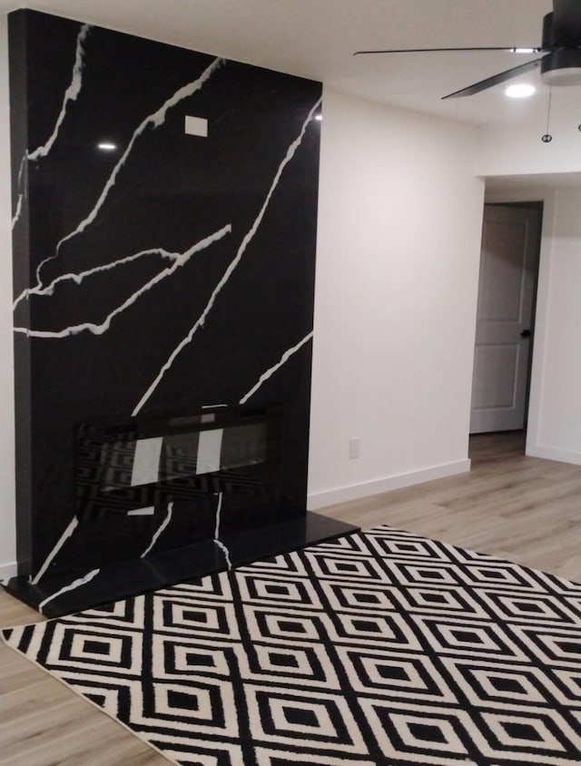 unfurnished room with a ceiling fan, light wood-style floors, and baseboards