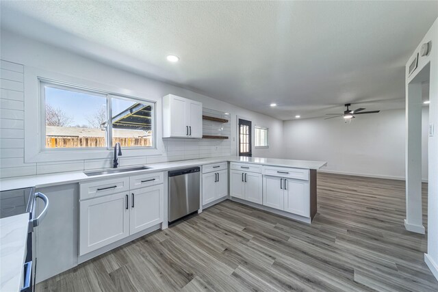 kitchen featuring a sink, dishwasher, a peninsula, range with electric cooktop, and a ceiling fan