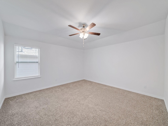 carpeted empty room featuring a ceiling fan and baseboards