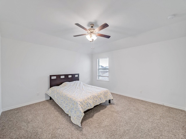 carpeted bedroom with ceiling fan and baseboards