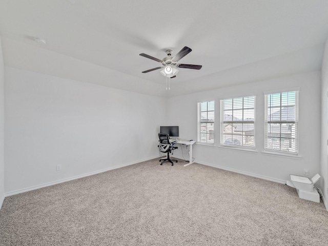 unfurnished office with a ceiling fan, light carpet, and baseboards