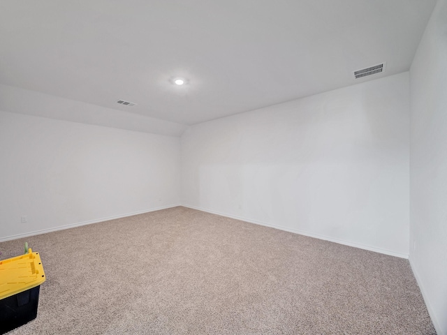 spare room featuring carpet, visible vents, and baseboards