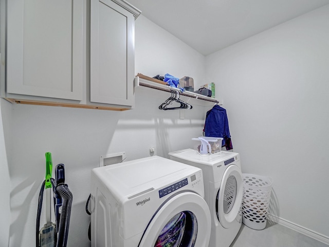 laundry area with baseboards, cabinet space, and washer and dryer