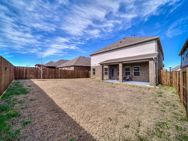 back of house with brick siding, a patio area, and a fenced backyard