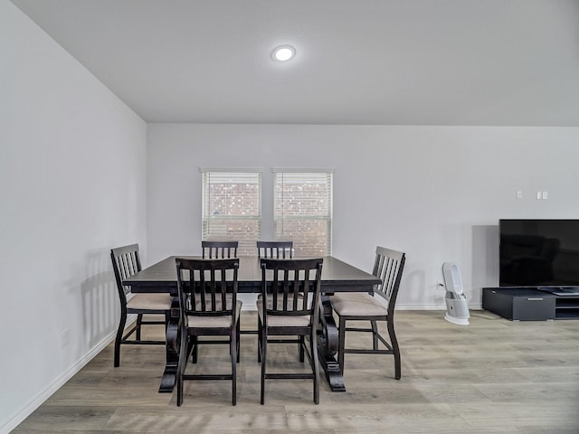 dining area with baseboards and wood finished floors