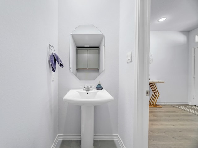 bathroom with baseboards and wood finished floors