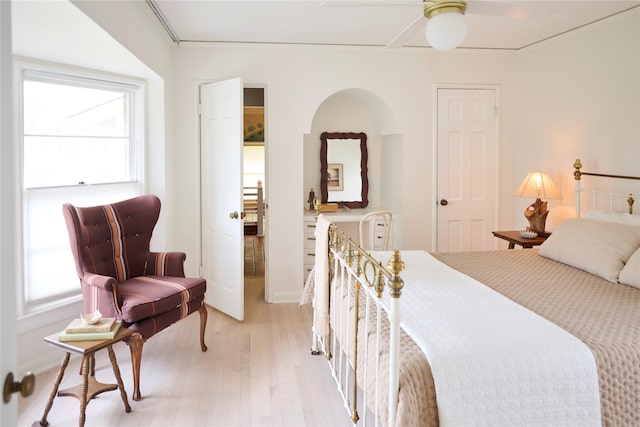 bedroom featuring ceiling fan, multiple windows, and light wood-style flooring