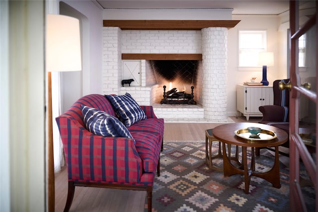 living room with ornamental molding, a fireplace, and wood finished floors