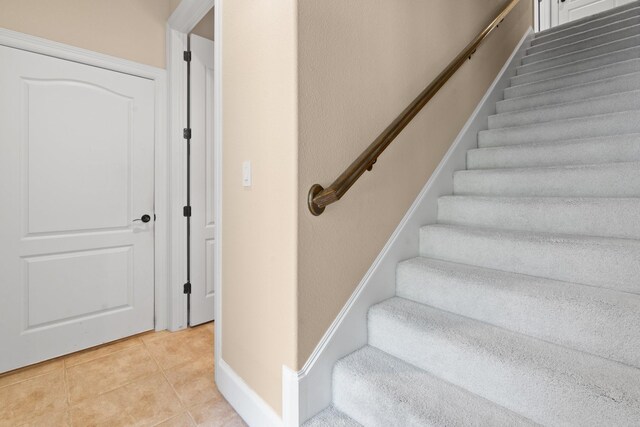 stairs featuring tile patterned flooring and baseboards