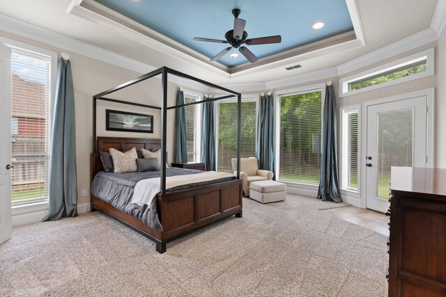 carpeted bedroom with a tray ceiling, ornamental molding, multiple windows, a ceiling fan, and recessed lighting