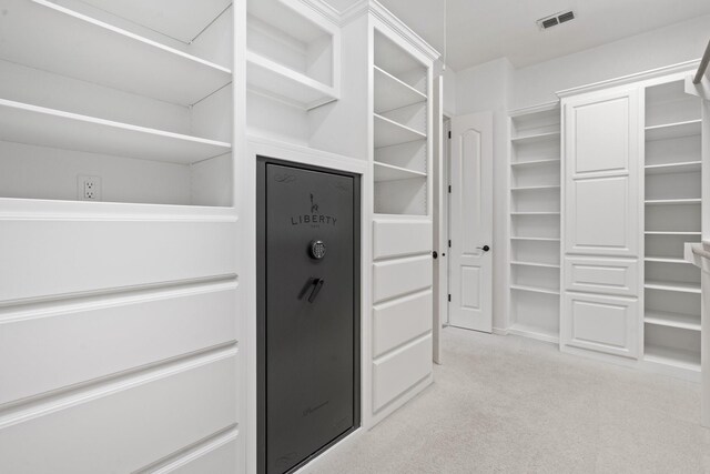 walk in closet featuring light carpet