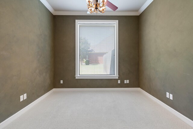 empty room featuring carpet floors, ornamental molding, ceiling fan, and baseboards