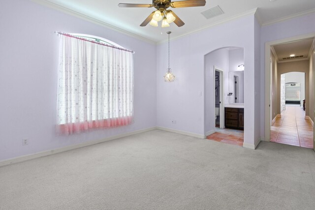 empty room featuring arched walkways, carpet, plenty of natural light, ceiling fan, and ornamental molding